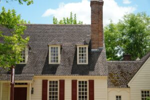 a white house with red shutters and a chimney