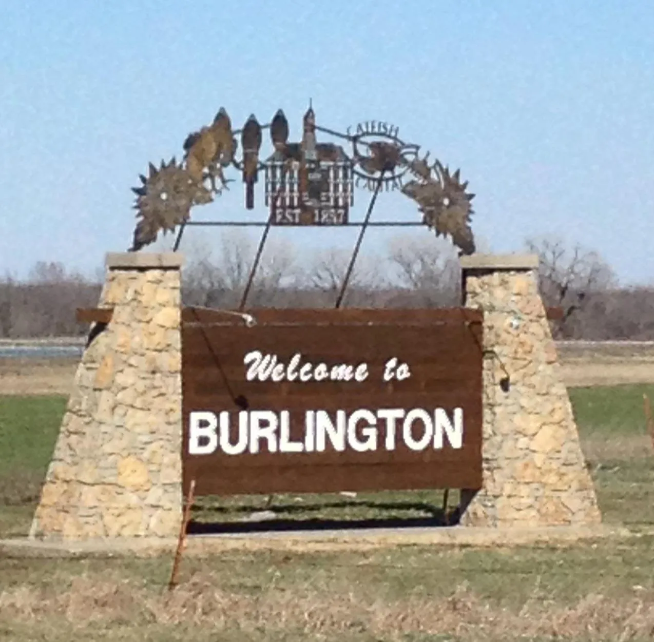 A metal and limestone sign reads Welcome to Burlington